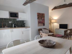 a kitchen and living room with a table and chairs at Grand appart 2 chambres - Hyper centre - Calme in Chinon