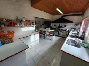 a large kitchen with white counters and a sink at Vulcanche in Villa Traful