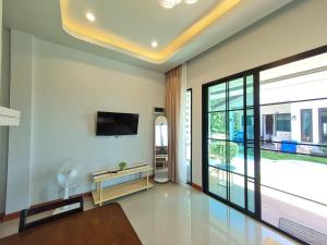 a living room with a large window and a tv at Samati Hill - Pool Villa H2- Klong Ning Beach in Ko Lanta Yai