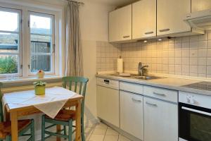 a kitchen with a table and a sink and a table and chairs at Haus Arfsten "Elena", Nieblum in Nieblum