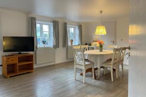 a dining room with a table and a television at Haus Arfsten "Elena", Nieblum in Nieblum
