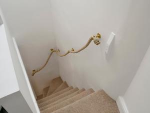 a stairway with aige carpet and a stair railing at Time Cottage in Coltishall