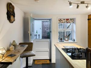 a kitchen with a counter and a stove top oven at Time Cottage in Coltishall