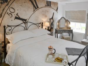 a white bed with a tray of food on it at Time Cottage in Coltishall