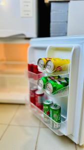 an open refrigerator door with soda cans in it at Monoambiente Eldorado 1 in Eldorado
