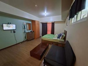 a room with a bed and a table in it at Celadon Tower- Studio with balcony near SM San Lazaro in Manila