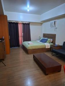 a bedroom with a bed and a coffee table at Celadon Tower- Studio with balcony near SM San Lazaro in Manila