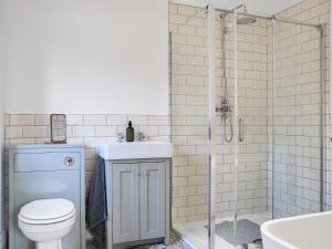 a bathroom with a toilet and a shower and a sink at Kestrel Cottage in Holmfirth +7 photos