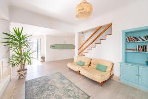 a living room with a couch and a staircase at SURFinn Lisbon in Costa da Caparica