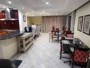 a kitchen and dining room with tables and chairs at Orchids Lodge in Fourways