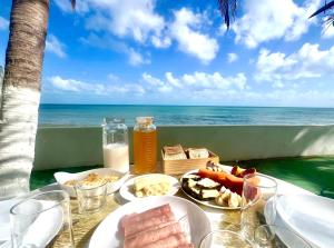 a table with food and the ocean in the background at Casa La France in Caucaia