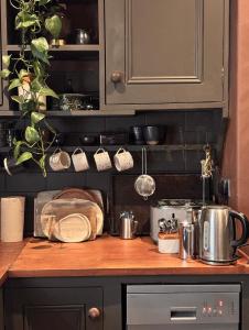a kitchen counter with pots and pans on a shelf at The Goose Garden in Hebden Bridge
