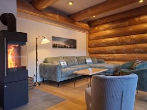 a living room with a couch and a fireplace at Ferienblockhaus "Glashütte" mit Sauna, Todtmoos in Todtmoos