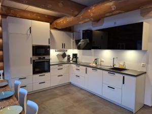 a large kitchen with white cabinets and appliances at Ferienblockhaus "Glashütte" mit Sauna, Todtmoos in Todtmoos