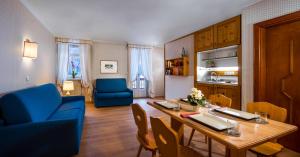 a living room with a table and a blue chair at Villaggio Turistico Ploner in Carbonin