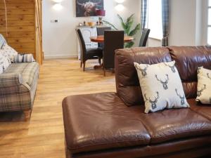 a brown leather couch sitting in a living room at Rhoshill in Llanfyrnach