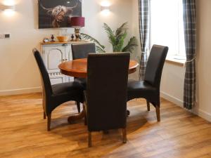 a dining room with a wooden table and chairs at Rhoshill in Llanfyrnach