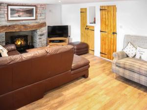 a living room with a couch and a fireplace at Rhoshill in Llanfyrnach