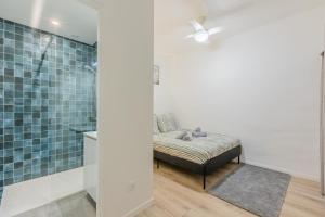 a bathroom with a bed and a shower at Résidence Sébastopol - Appartements Hyper Centre - WiFi & Smart TV in Béziers