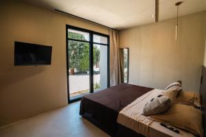 a bedroom with a large bed and a large window at La Vague - Saint Tropez in Saint-Tropez +11 photos