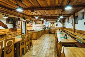 a restaurant with wooden tables and benches in a room at U GORAĽA in Lesnica
