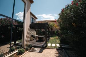 a house with a wooden deck with a table in the yard at La Vague - Saint Tropez in Saint-Tropez