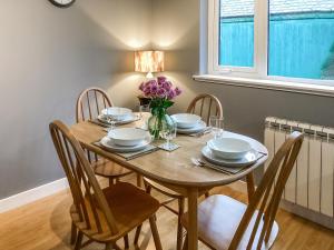 a dining room table with chairs and purple flowers on it at Uppermill Farm in Tarves