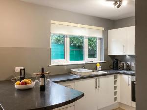 a kitchen with a sink and a bowl of fruit on a counter at Uppermill Farm in Tarves