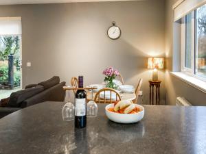 a bottle of wine sitting on a table with a bowl of bread at Uppermill Farm in Tarves