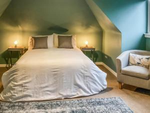 a bedroom with a large bed and a chair at Uppermill Farm in Tarves +5 photos