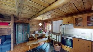 a kitchen with wooden cabinets and a table in a room at Heidi Hütte in Döllach +5 photos