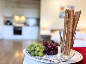 a plate of grapes and crackers on a table at Jutta vom Kutter in Wulfen auf Fehmarn