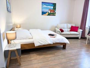 a bedroom with a bed and a couch and a chair at Jutta vom Kutter in Wulfen auf Fehmarn