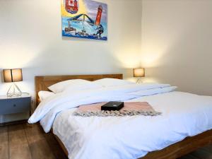 a bedroom with a large white bed with two lamps at Jutta vom Kutter in Wulfen auf Fehmarn +9 photos