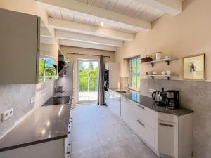 a kitchen with white cabinets and a large window at Ferienhaus Libelle - Feriendomizil für 14 Pers - Haupt- und Nebenhaus in Rankwitz