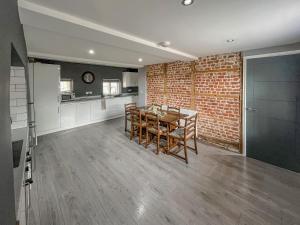 a kitchen and dining room with a brick wall at Forge Cottage in Canterbury