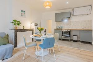 a kitchen and living room with a table and chairs at Résidence Sébastopol - Appartements Hyper Centre - WiFi & Smart TV in Béziers