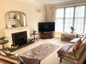 a living room with a fireplace and a television at Upperton Townhouse in Eastbourne