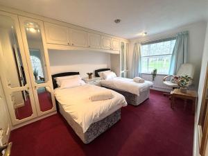 a bedroom with two beds and a window at Upperton Townhouse in Eastbourne