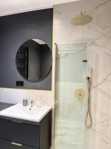 a bathroom with a sink and a shower with a mirror at Justinrent 1 in Legnica +19 photos