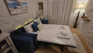 a bedroom with a large bed and a blue couch at Stunning Sea-View Villa w Access to Shared Pools in Mikonos