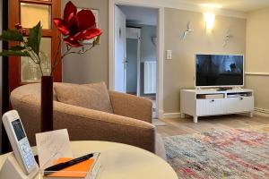 a living room with a couch and a tv at Haus 25 in Oldsum in Oldsum