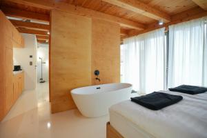 a bathroom with a bath tub next to a bed at GG3 guesthouse in Eger +41 photos