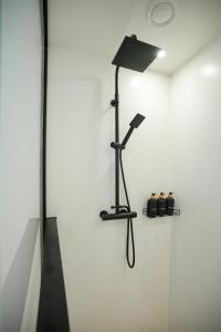 a bathroom with a shower with a lamp on a wall at GG3 guesthouse in Eger
