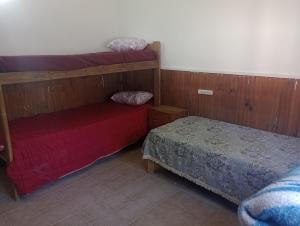 a bedroom with two bunk beds and a red bed at La casita lila in Mar de Ajó
