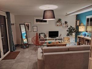 a living room with a couch and a table at Chez CoCo in Manteyer
