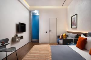 a hotel room with a bed and a couch at Blueloft 47 l studio with balcony Tashkent City Center in Tashkent