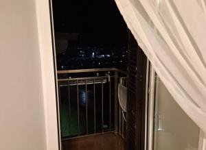 a balcony with a view of the city at night at Little Medieval House Nettuno in Nettuno