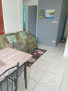 a living room with a couch and a table at Jolly's Mountain Side Guest House in Roseau