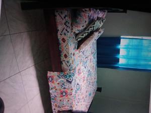 a person in a dress is standing on a bed at Jolly's Mountain Side Guest House in Roseau